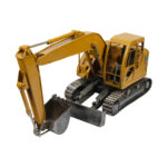 Sarı metal gövdesi, paletli yürüyüş sistemi, uzun kazıcı kolu, metal kepçesi, hidrolik silindir detayları, sürücü kabini ve ön dozer bıçağı bulunan vintage ekskavatör iş makinesi maketi.