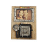 Vintage fotoğraf makinesi tasarımlı, ahşap zemin üzerine metal kamera detayları bulunan dekoratif fotoğraf çerçevesi.