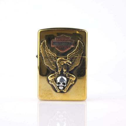 Orijinal Zippo Armor çakmak, gold gövdesi, Harley-Davidson teması, kartal ve kurukafa detaylı kabartmalı tasarımıyla öne çıkan kalın gövdeli premium Zippo çakmak modeli – Ateş Premium Armor Zippo koleksiyonu.