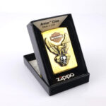 Orijinal Zippo Armor çakmak, gold gövdesi, Harley-Davidson teması, kartal ve kurukafa detaylı kabartmalı tasarımıyla öne çıkan kalın gövdeli premium Zippo çakmak modeli – Ateş Premium Armor Zippo koleksiyonu.